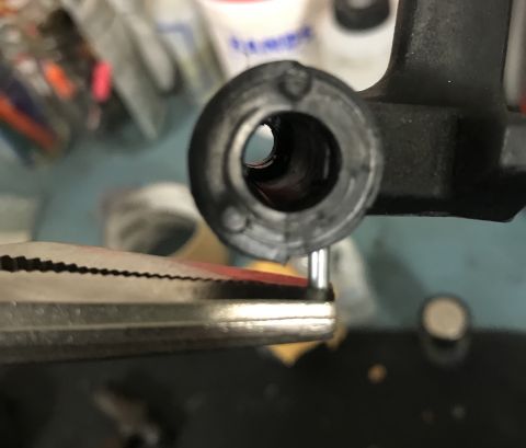 1995 Ford Bronco - Close-up of pliers holding a pin near a black plastic part.