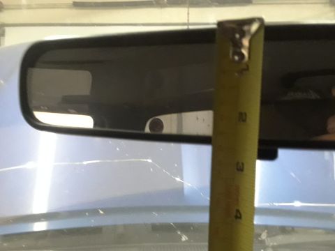 1996 Ford F-350 - A tape measure is held up to a vehicle's rear view mirror, showing measurements in inches.