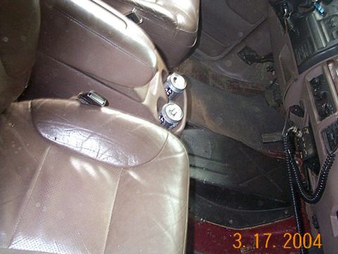 1986 Ford Bronco - Interior view of truck or SUV seats and center console with two cans in the cup holder.