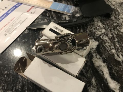 1923 Ford Model T - A chrome universal joint is shown with a safety recall notice and a knife.