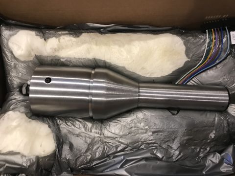 1923 Ford Model T - A metal automotive part, possibly a drive shaft component, is shown in its packaging with electrical wires visible.