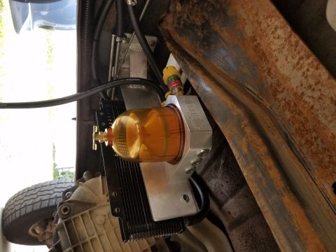 1995 Ford F-250 - Close-up view of a fuel filter assembly installed on the underside of a vehicle.