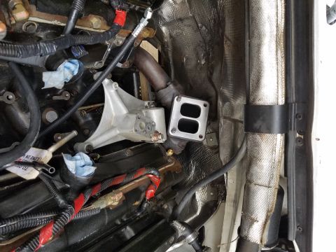 1995 Ford F-250 - Close-up view of engine components, including a turbocharger exhaust flange and associated plumbing.