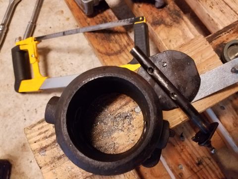 1995 Ford F-250 - A disassembled EBPV delete part sits on a wooden surface with a hacksaw and other tools nearby.