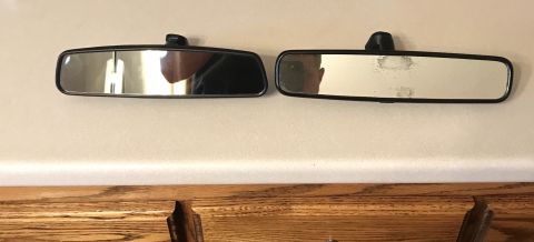 1995 Ford Bronco - Two interior rearview mirrors are shown mounted on a wall above a wooden surface.