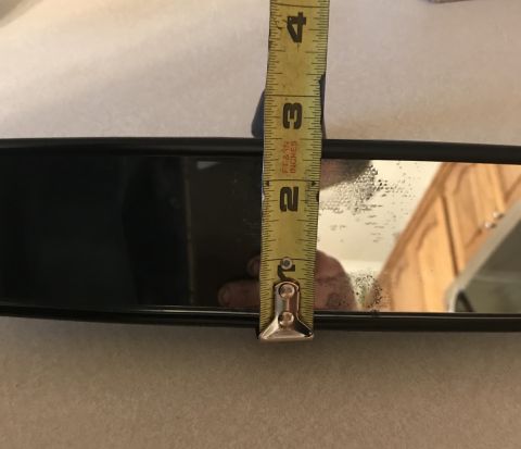 1995 Ford Bronco - A measuring tape is held against a vehicle's rear-view mirror.