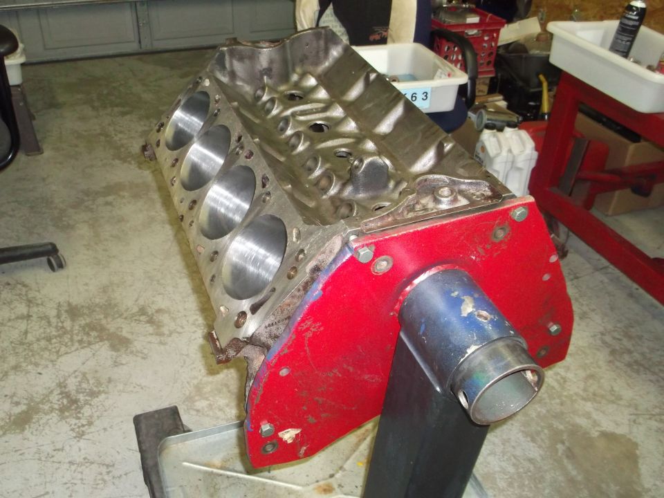 Engine block on red stand with blue exhaust pipe