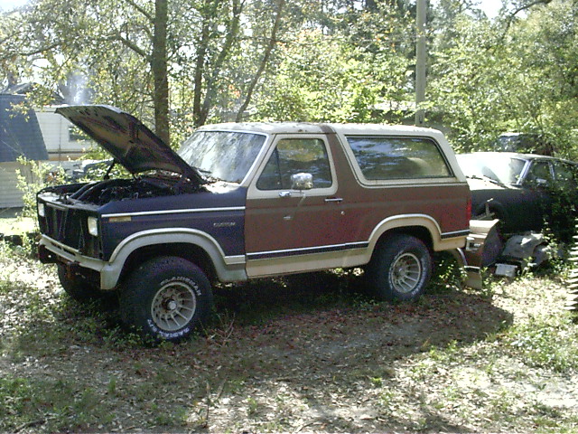 1985 Ford Bronco, 3q-front view, brown and tan with hood open. Another vehicle is partially visible behind it