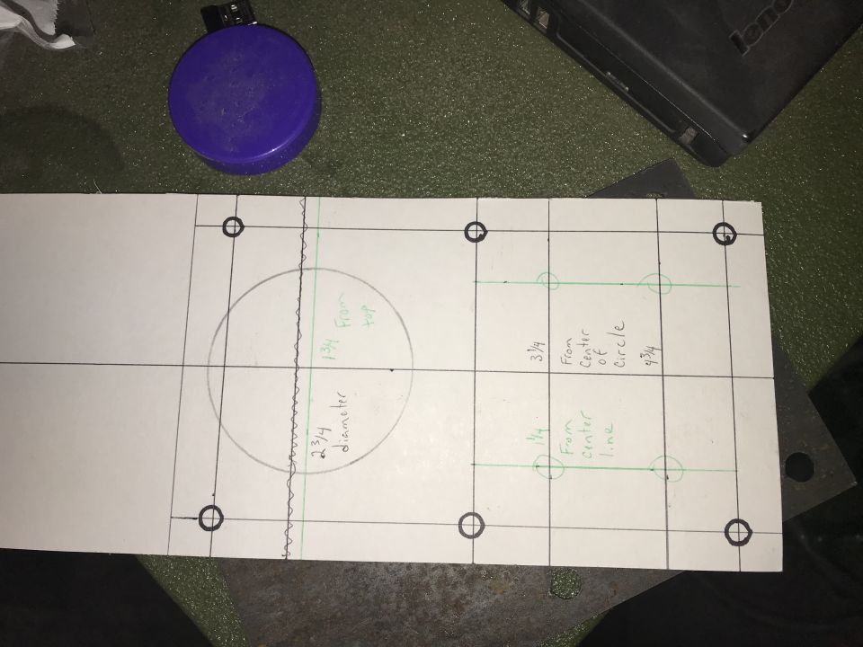 Hand-drawn dimensioned drilling template on white panel with grid lines and measurements