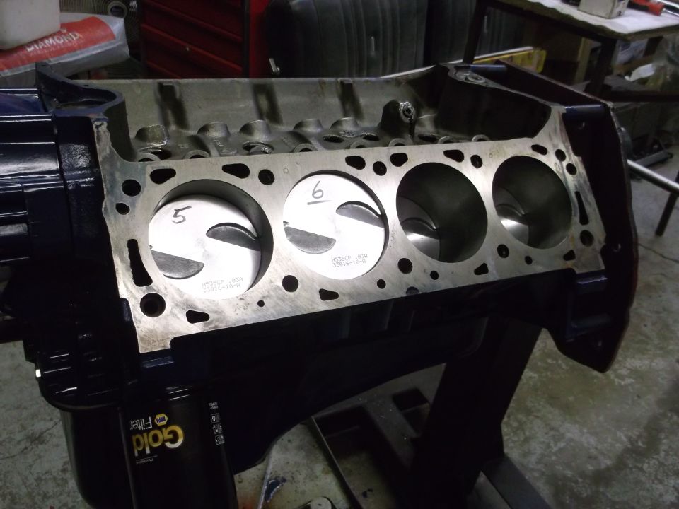 Engine block with pistons numbered 5 and 6 visible. Gold oil filter attached