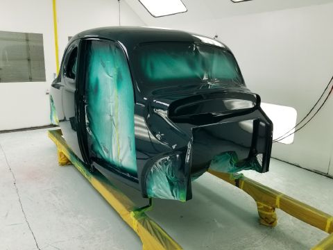 1940 Ford Coupe - A dark colored car is being prepped for painting, with green masking protecting areas not being painted.