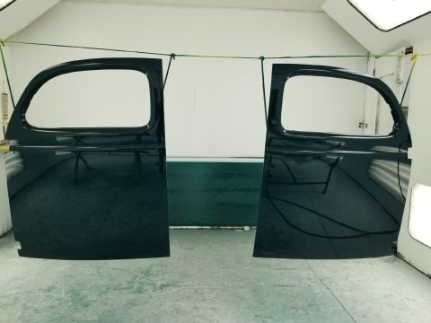 1940 Ford Coupe - Two car doors are suspended in a paint booth, awaiting further work.