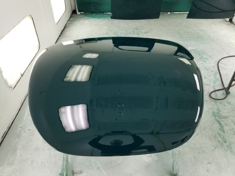 1940 Ford Coupe - A car hood is shown in a paint booth, reflecting the surrounding environment.