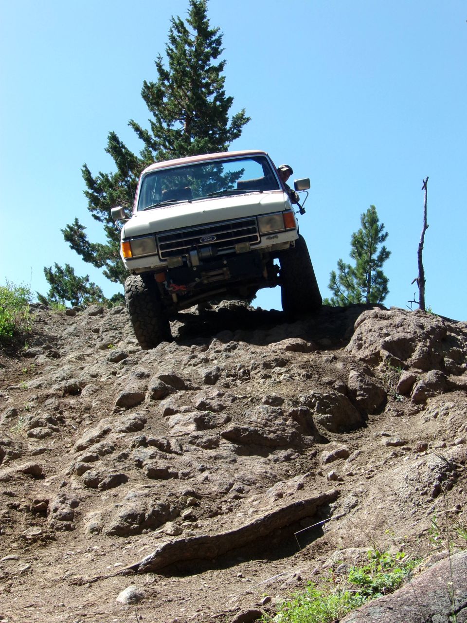 White Ford Bronco with a winch, climbing a rocky incline