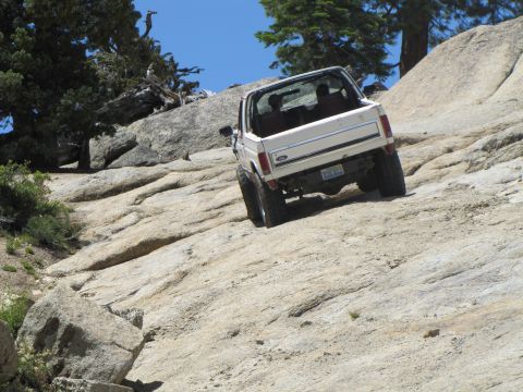 1984 Ford Bronco - 1984 Ford Bronco navigating a challenging rocky trail off-road.