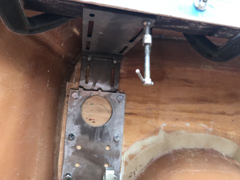 1923 Ford Model T - Close-up view of a metal bracket and hardware assembly mounted on a wooden surface.