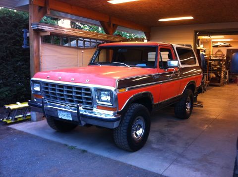 1978 Ford Bronco - This two-tone orange and brown 1978 Ford Bronco is captured from a three-quarter front view, parked indoors.