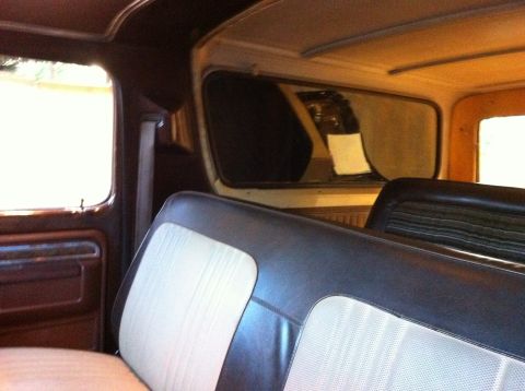 1978 Ford Bronco - The interior of a vehicle is shown, focusing on the rear seating area and door panel details.
