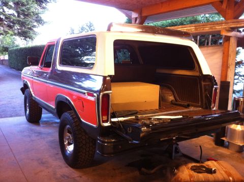 1978 Ford Bronco - Rear view of a 1978 Ford Bronco with its tailgate down, revealing a large wooden box inside.