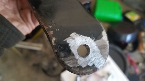 1985 Ford Bronco - Metal bracket with a hole, likely a vehicle part, showing signs of modification or wear.