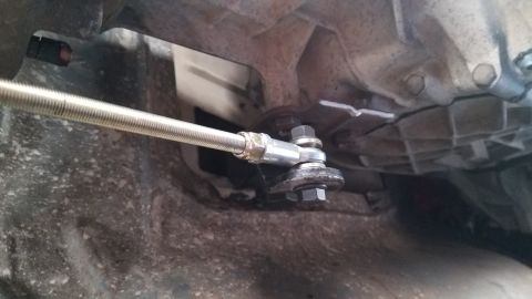 1985 Ford Bronco - Underside view of a vehicle's transmission linkage mechanism.