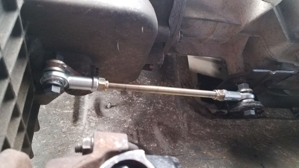 Transmission linkage with adjustable rod connecting two points on a vehicle's drivetrain