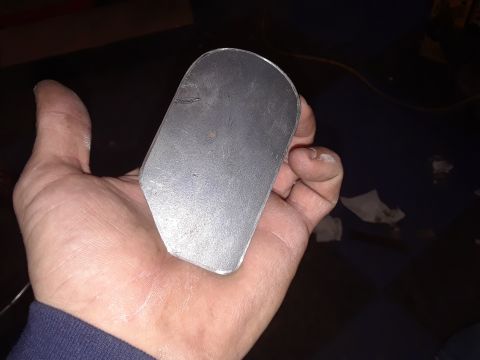 1985 Ford Bronco - A person holds a custom-shaped metal part in their palm.