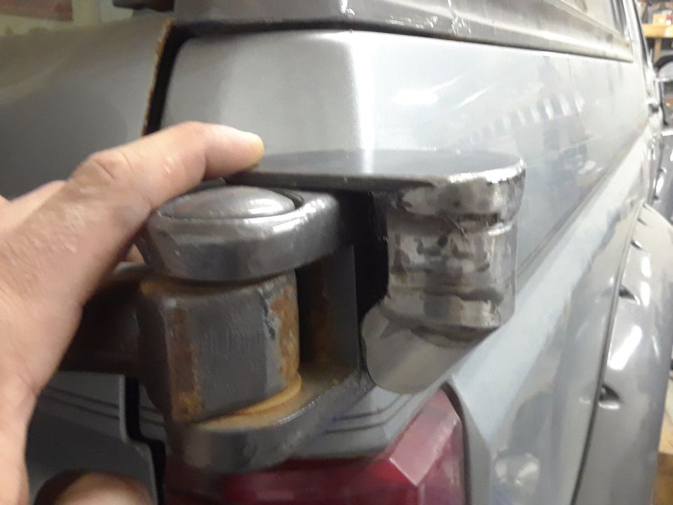Close-up of a trailer hitch receiver with a ball mount attached. A hand is visible near the mount