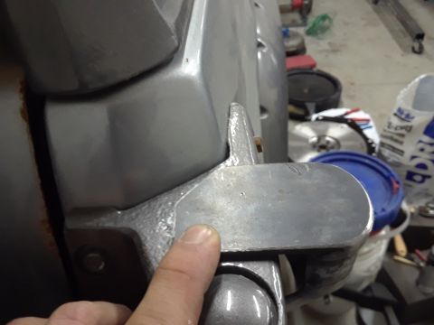 1985 Ford Bronco - A close-up view of a metal bracket, with a finger indicating a specific point of interest on its surface.
