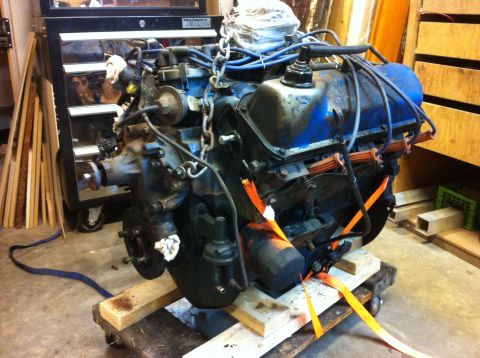 1978 Ford Bronco - Engine assembly, likely for a Ford Bronco, is secured with straps on a pallet.
