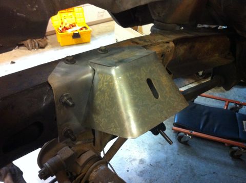1978 Ford Bronco - A custom metal bracket is being installed onto the frame of a vehicle, likely during a modification process.