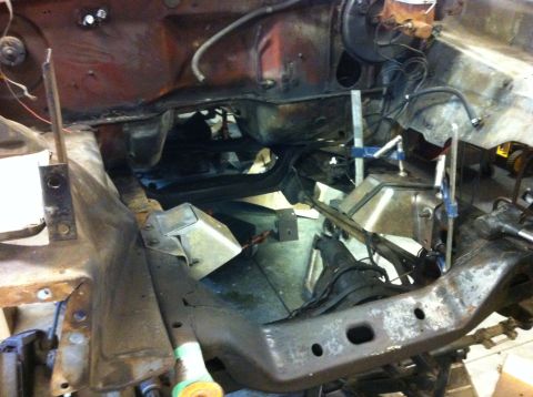 1978 Ford Bronco - The engine bay frame shows significant rust and is partially disassembled, with metal bracing and hoses visible.