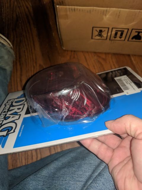 2014 Harley-Davidson FXDWGI Wide Glide - A person holds a red motorcycle tail light in its packaging.