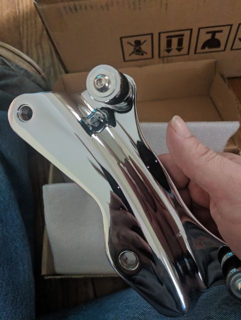 2014 Harley-Davidson FXDWGI Wide Glide - A chrome motorcycle part is held in a hand, with a cardboard box in the background.