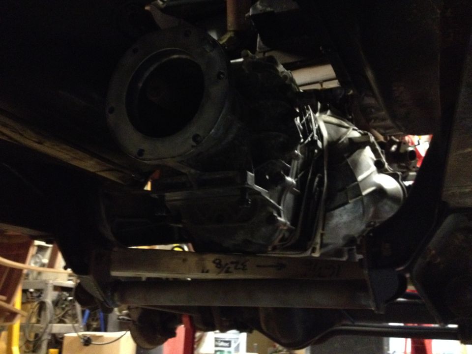 Underside view of a vehicle's transmission and driveshaft, with visible markings of "9 7/8"