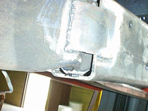 1995 Ford Bronco - Detail of a welded bracket on a vehicle's undercarriage.
