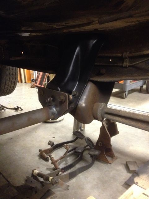 1978 Ford Bronco - A close-up view of a vehicle's undercarriage, showing suspension parts and detached pedals.
