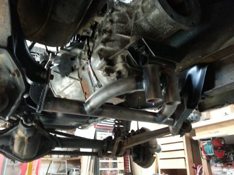1978 Ford Bronco - An underside view of a vehicle's drivetrain, showing the transmission, exhaust system, and rear axle components. Custom exhaust piping and…