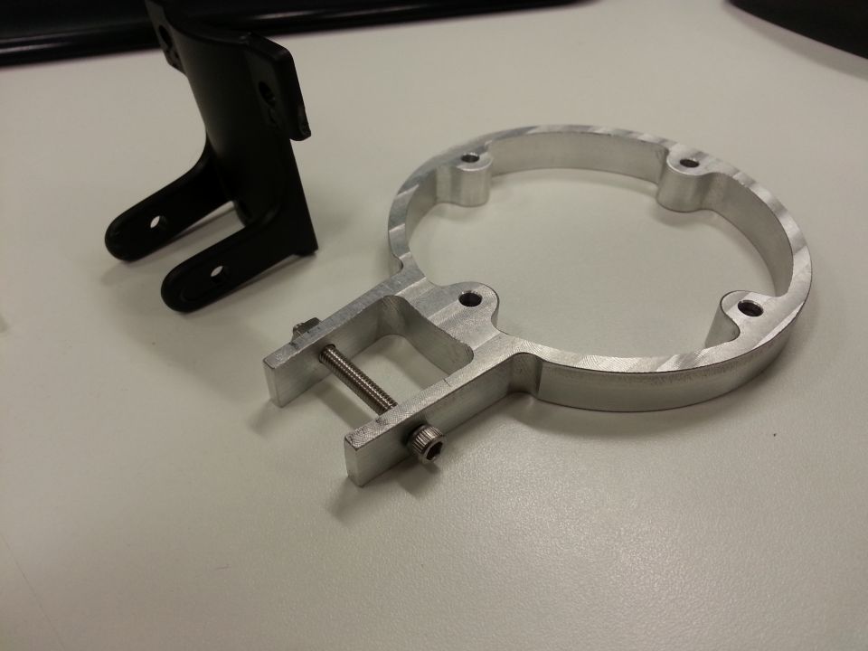 Black plastic bracket and silver aluminum ring clamp with bolt and nut.