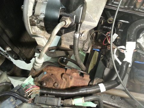 1978 Ford Bronco - This close-up image shows a section of an engine bay, focusing on the power steering pump, hoses, and wiring harnesses. The components appe…