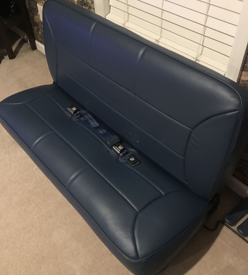 Navy blue bench seat with seat belts, interior vehicle part.