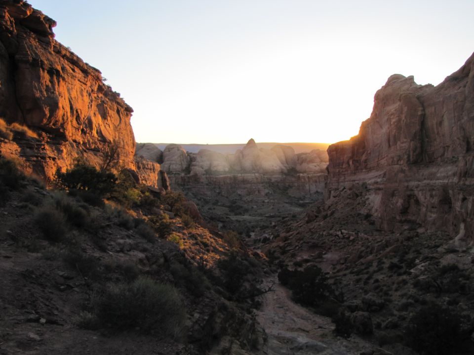 Canyon landscape at sunset with sunlit rock formations.