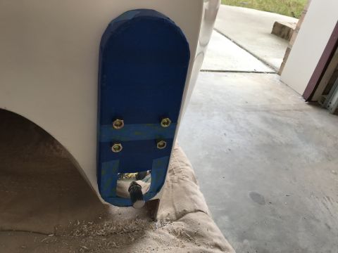 1923 Ford Model T - A close-up view of a blue taped area on a white vehicle body, secured by four bolts and nuts. A silver knob or lever protrudes from the bot…