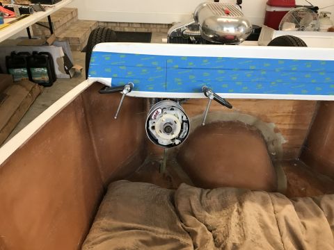 1923 Ford Model T - The interior of a custom build vehicle shows a fiberglass tub with tan padding and a chrome steering column assembly with two levers. A cir…