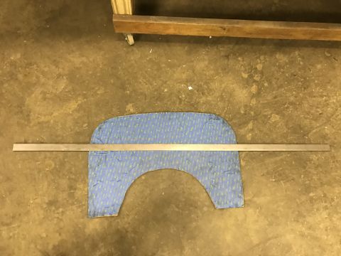 1923 Ford Model T - A metal ruler is placed horizontally across a blue patterned piece of material that is shaped like a car fender or wheel arch. The material…