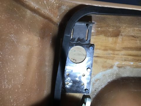 1923 Ford Model T - A metal bracket with a circular cutout is bolted to a wooden bulkhead inside a vehicle. A black rubber seal runs along the top edge of the…