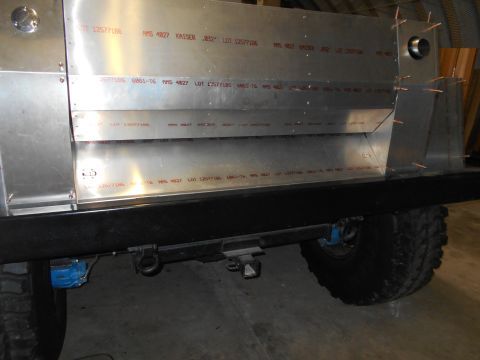 1992 Ford Bronco - The rear passenger side of a custom aluminum body being constructed on a vehicle chassis. Visible text on the aluminum panels indicates lot…