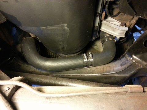 1978 Ford Bronco - A black radiator hose with two hose clamps is visible, connecting to an engine component. The hose is routed under the vehicle's frame.