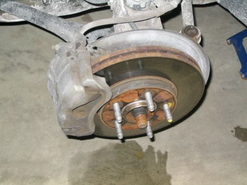 1996 Mercury Sable - Close-up view of a vehicle's brake caliper and rotor assembly.