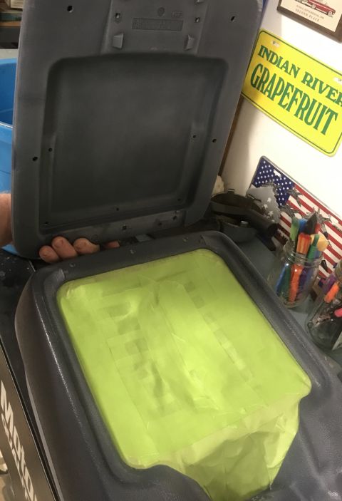 1995 Ford Bronco - A person's hand is holding the open lid of a dark gray center console storage compartment. The interior of the console is covered with brig…